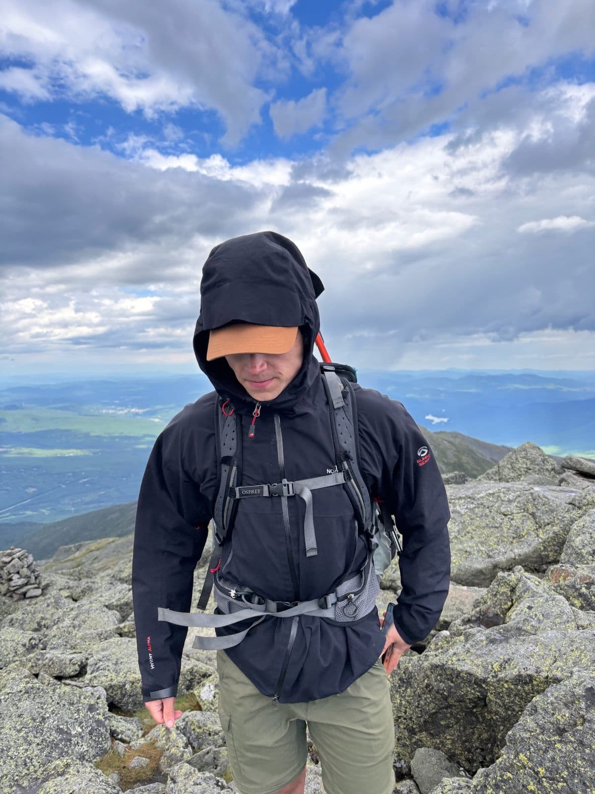 Judson on a rocky alpine summit above the clouds