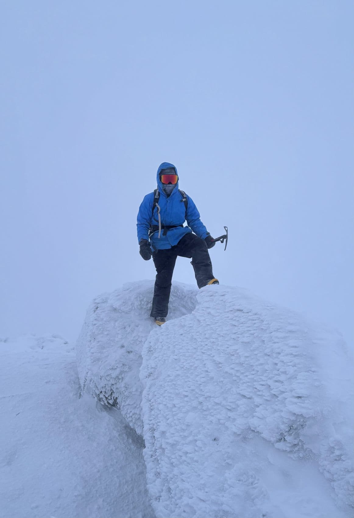 Judson on a rime-covered summit holding an ice axe