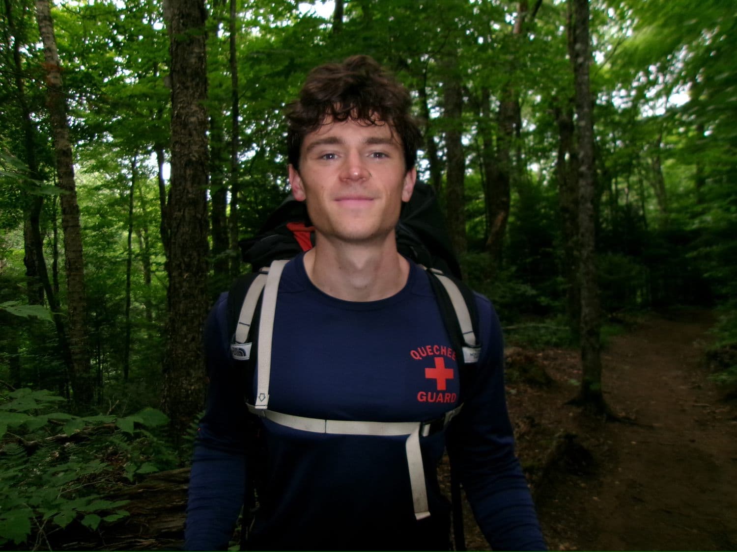 Judson on a green forest trail with a pack