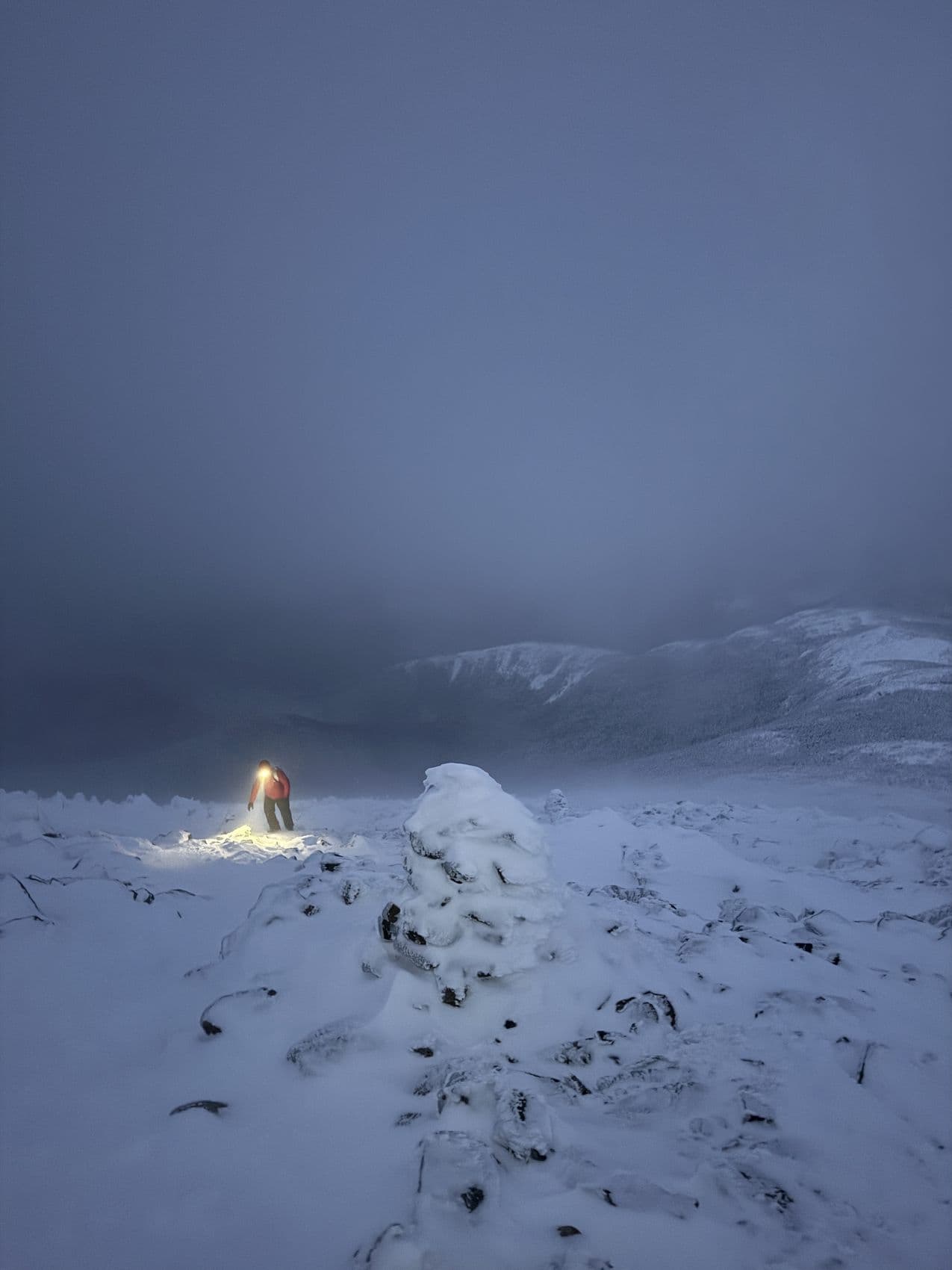 A figure on a summit in near whiteout conditions