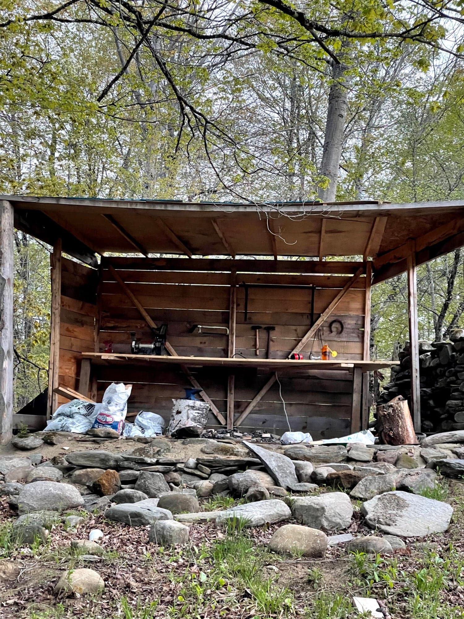The blacksmith shop part-built, its frame standing over the stone still stacked in front of it